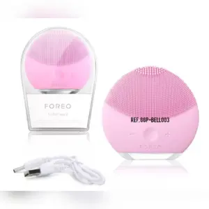 Cepillo limpiador facial Foreo Luna mini 2 de silicona color rosa con cerdas sónicas, caja transparente y cable cargador USB.